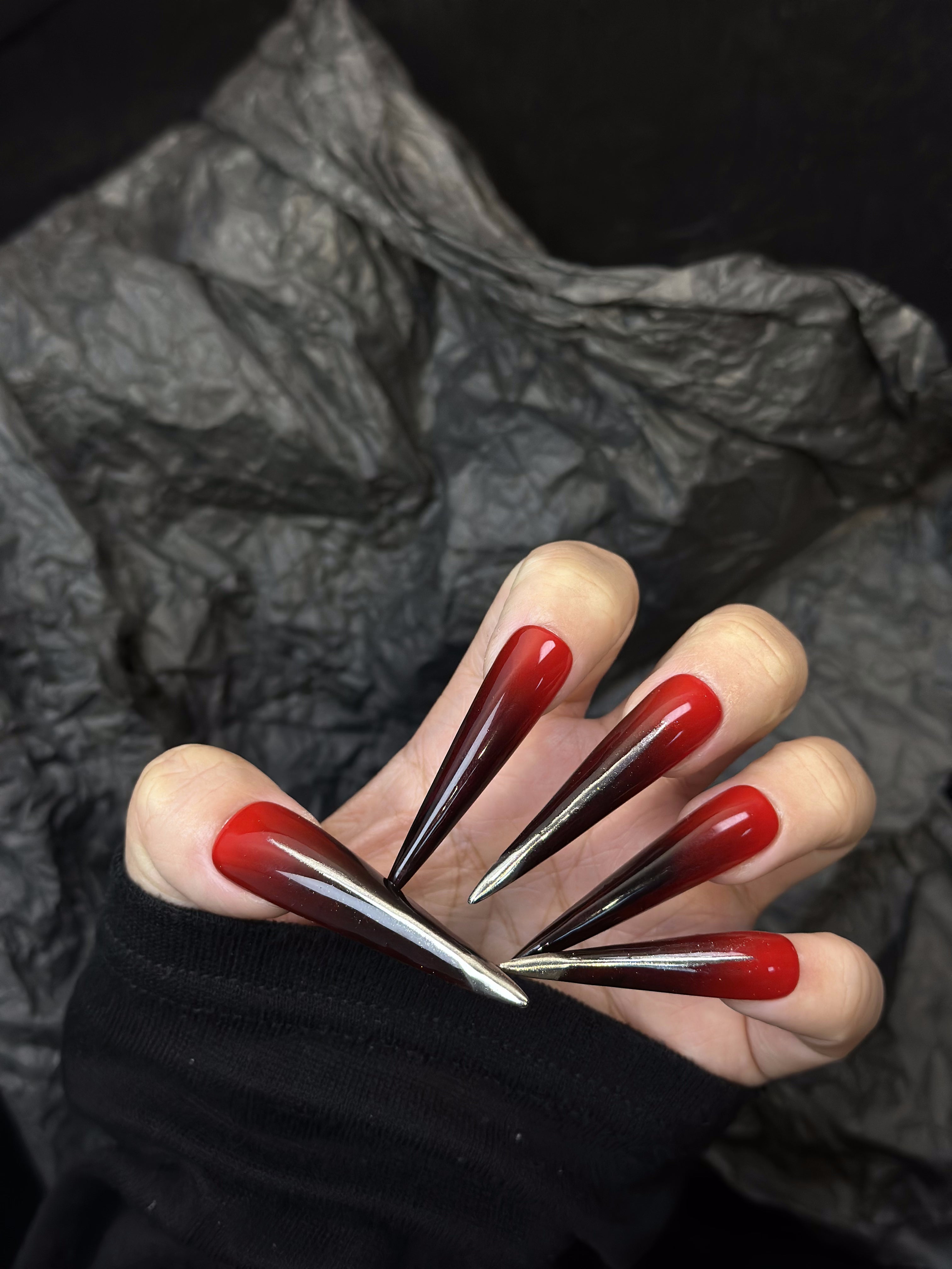 Lange schwarze und rote Stiletto-Ombre-Nägel