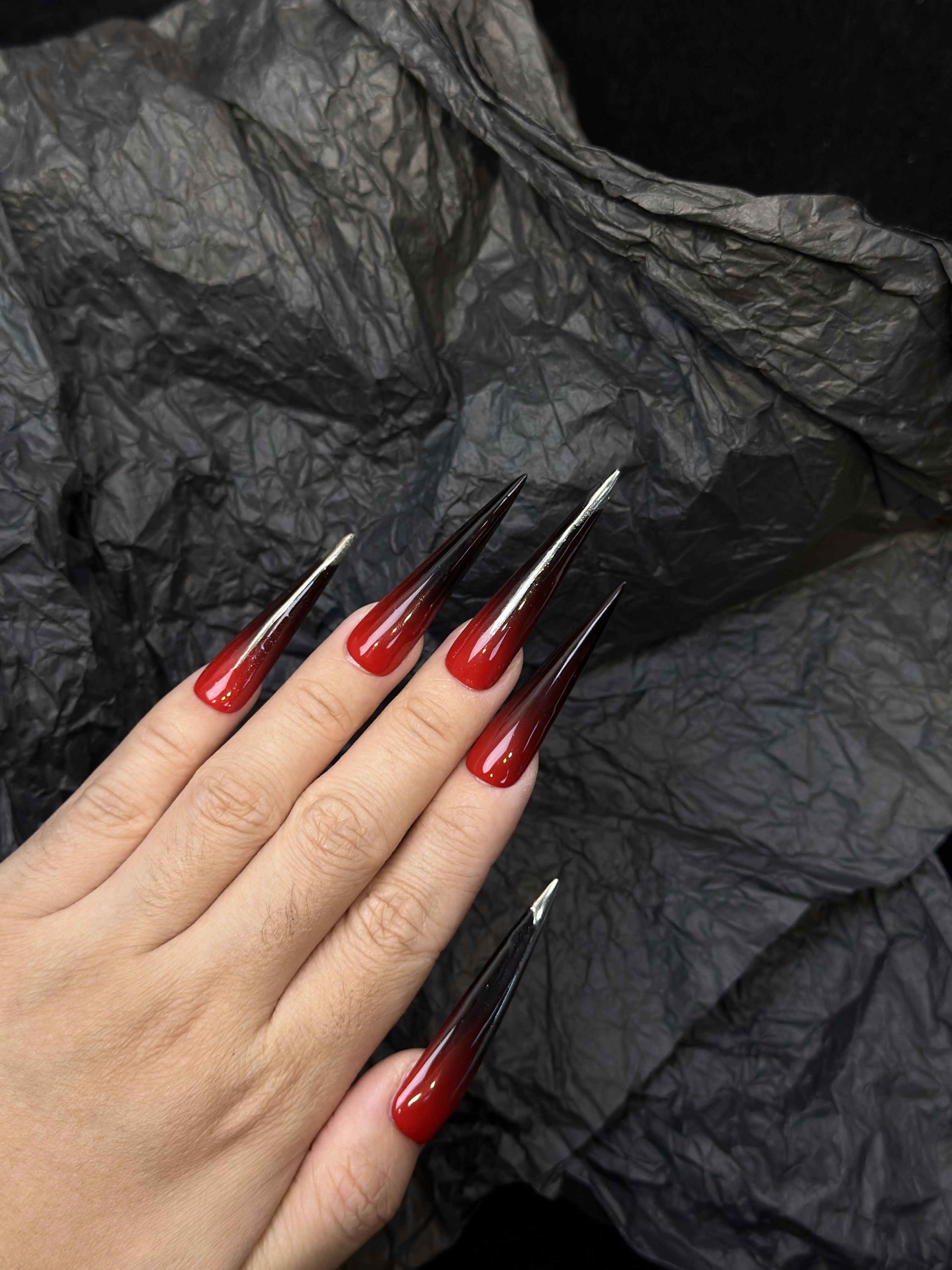 Lange schwarze und rote Stiletto-Ombre-Nägel